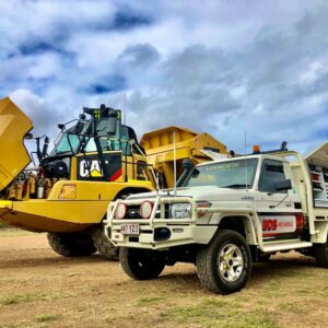 Yellow CAT machine and BDS Mechanical Repairs ute parked side by side