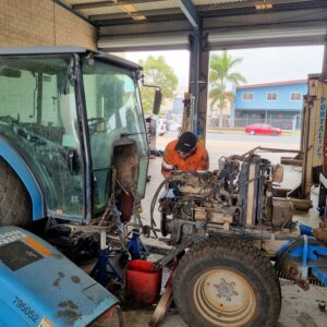 BDS Mechanic doing a service and repair on a blue tractor at the BDS Mechanical Repairs Mackay workshop