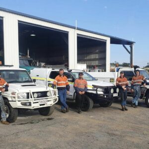 BDS Mechanical Repairs Gracemere mechanics standing in front of BDS utes and the workshop with blue skies